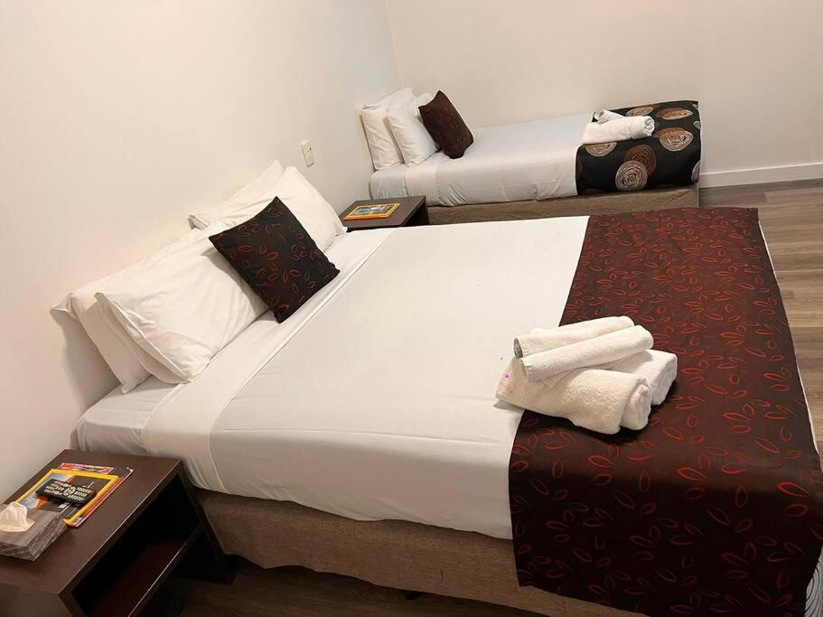 ein Hotelzimmer mit einem großen Bett mit Handtüchern darauf in der Unterkunft Ensuite gouger entire apartment in Adelaide