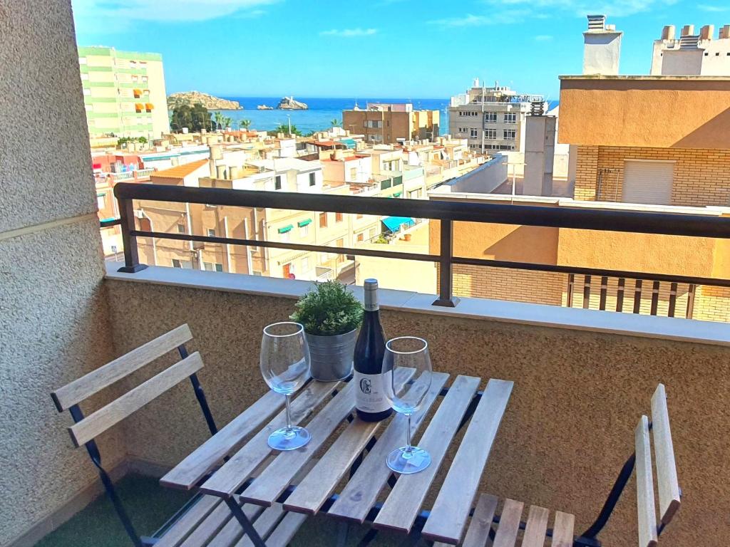 einen Tisch mit einer Flasche Wein und zwei Gläser auf dem Balkon in der Unterkunft Vistas al mar, céntrico y junto a la Estación - by Aloha Palma in Águilas