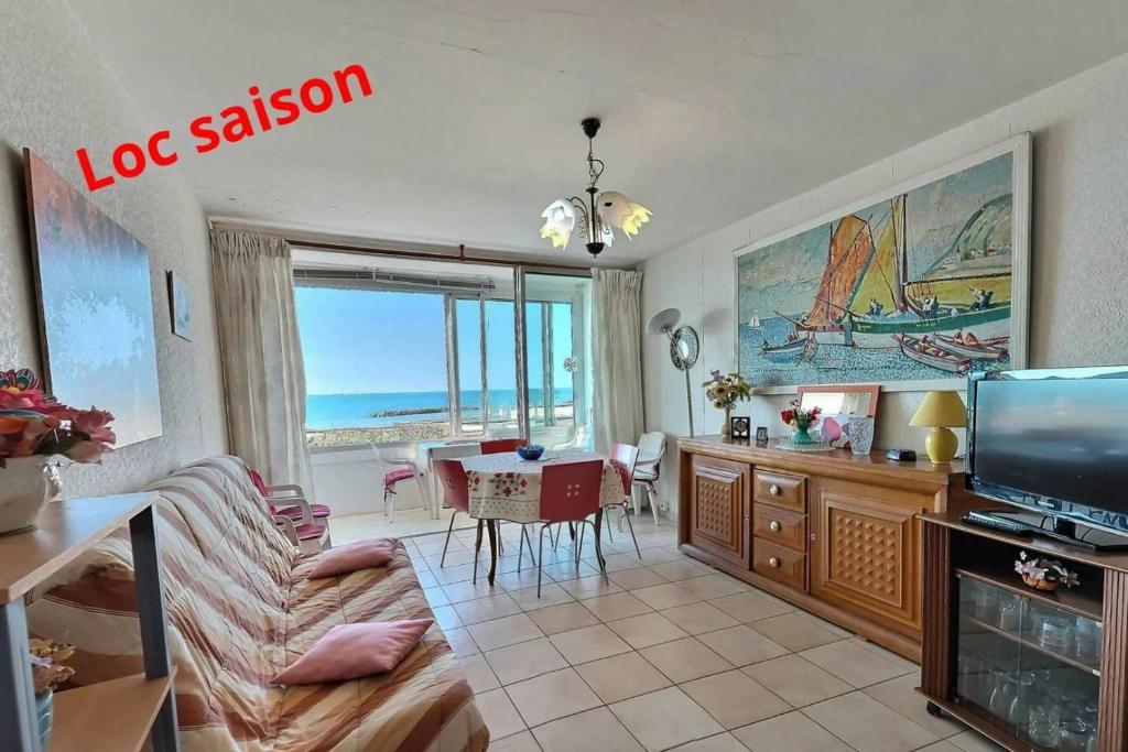 un salon avec un canapé et une table avec une télévision dans l'établissement Bore, à Valras-Plage
