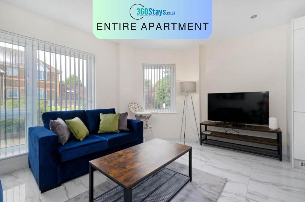 sala de estar con sofá azul y TV en Oxford Rd 2 Bed Serviced Apartment 06 with Parking, Reading By 360Stays en Reading