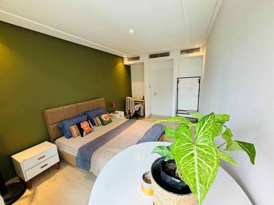 a bedroom with a bed and a table with a plant at Appartement Marsa Ville in La Marsa