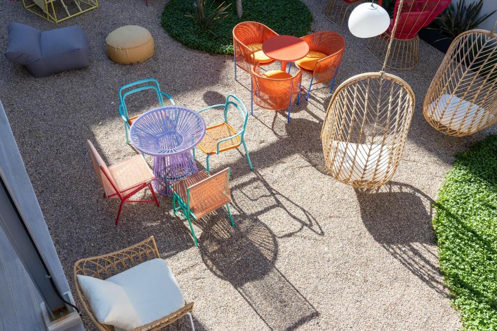 An overhead view highlights the courtyard's colorful café seating and woven hanging chairs.