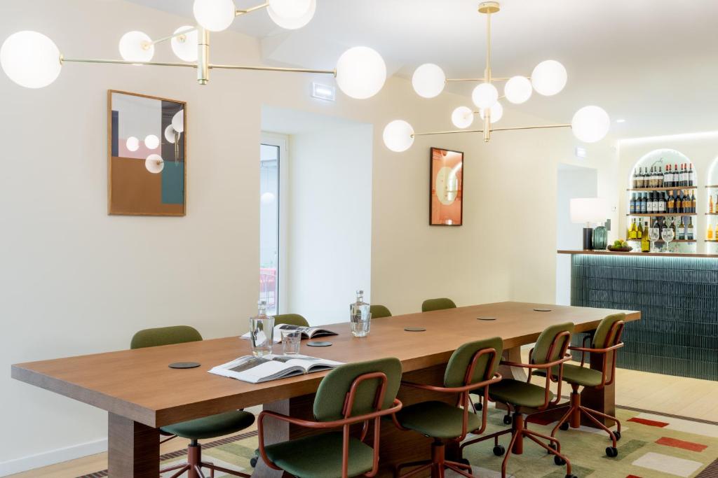 A communal dining room with a long wooden table beside a bar.