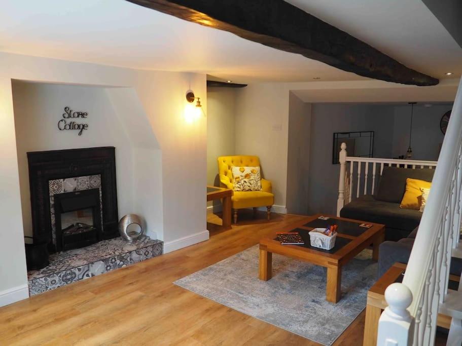 a living room with a fireplace and a couch at Stone Cottage in Morpeth