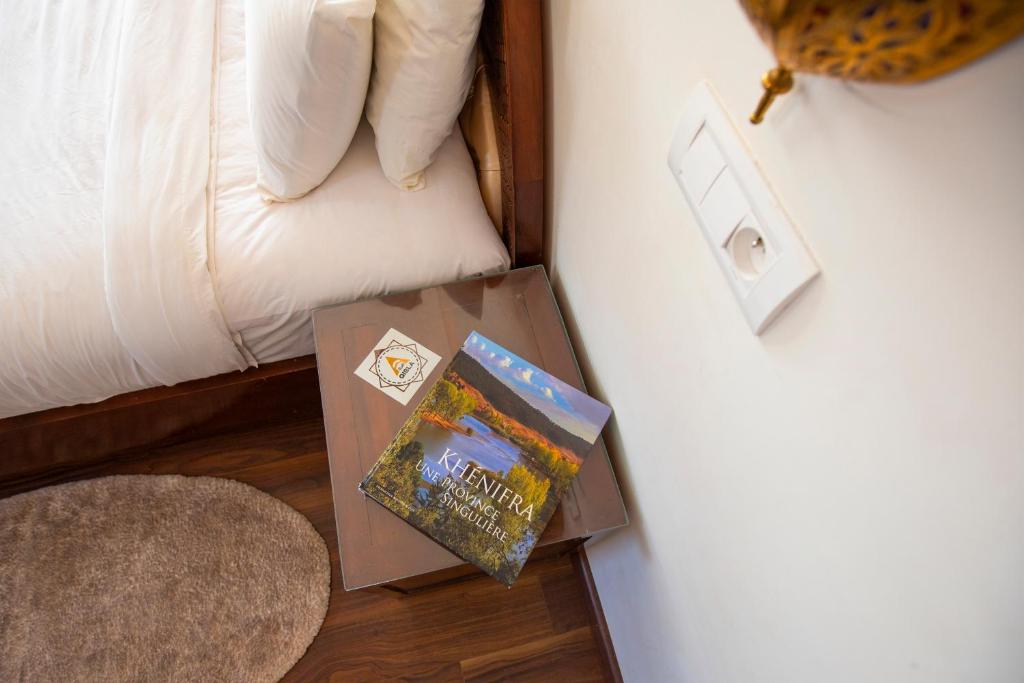 a table with books on it next to a bed at Dar Zayane in Khenifra