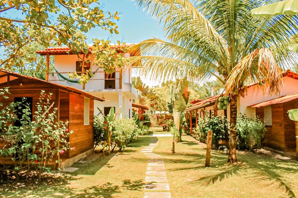 um pátio de uma casa com palmeiras e edifícios em Family Guest House na Ilha de Boipeba