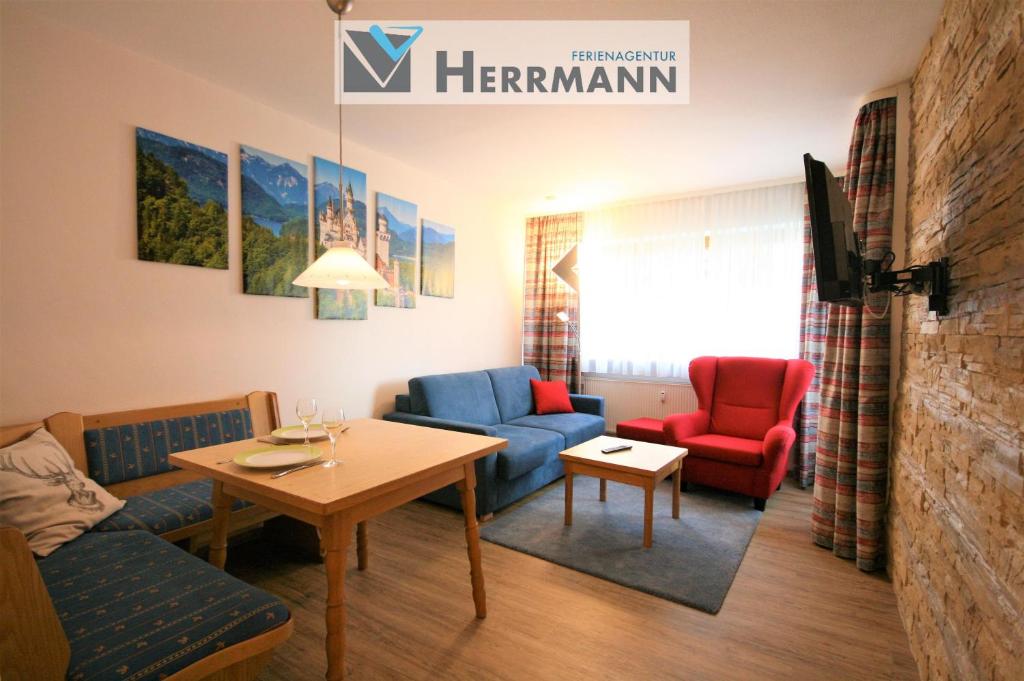 a living room with blue and red chairs and a table at Ferienwohnung Vera in Schwangau
