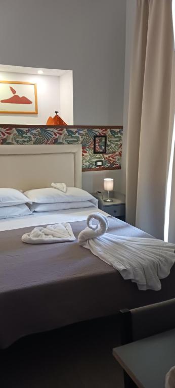 Welcome to I Colori di Napoli في نابولي: غرفه فندقيه سريرين عليها مناشف