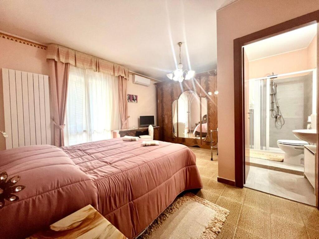 a bedroom with a large bed and a bathroom at Atinense Rooms in Pozzilli