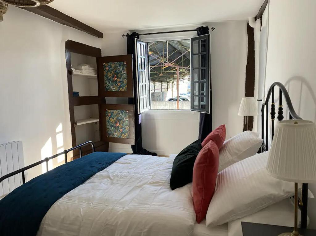 a bedroom with a large bed with a window at Maison - Les Traversières in Eymet