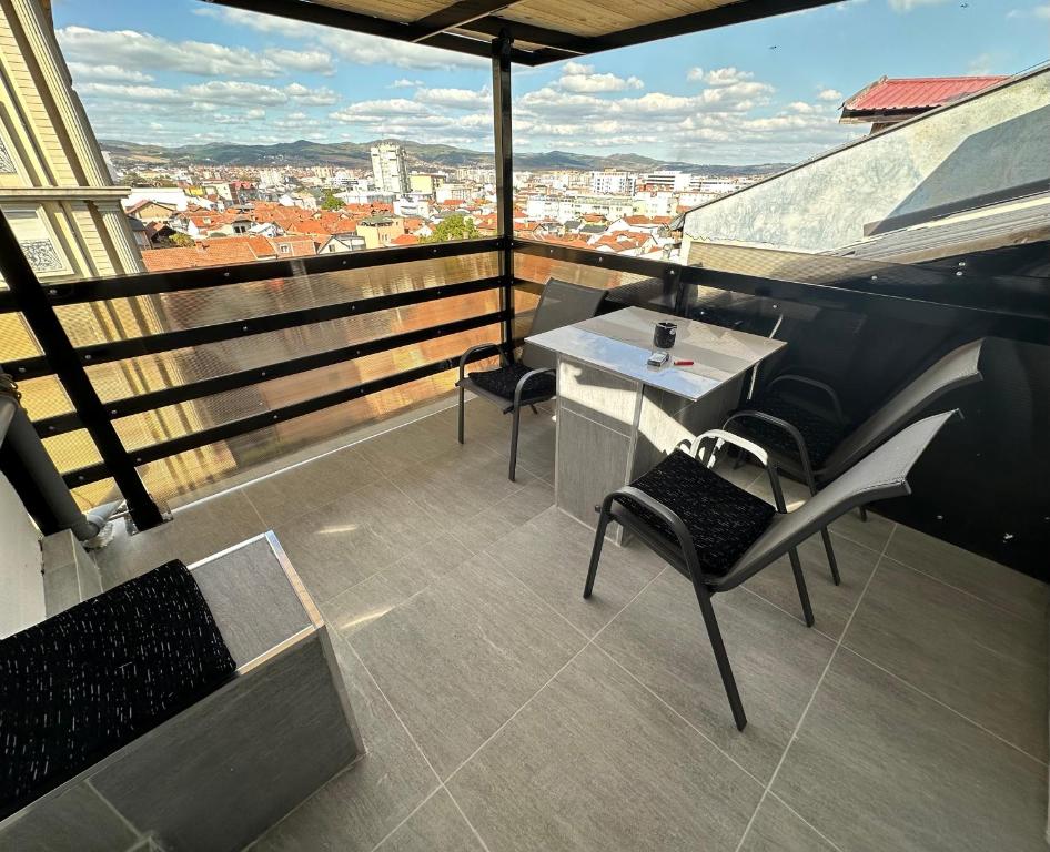 a balcony with a table and chairs on a building at SA Apartment in Gjilan