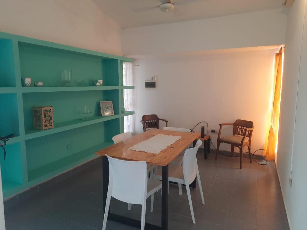 una sala da pranzo con tavolo e sedie in legno di casa familiar confortable a Santiago del Estero