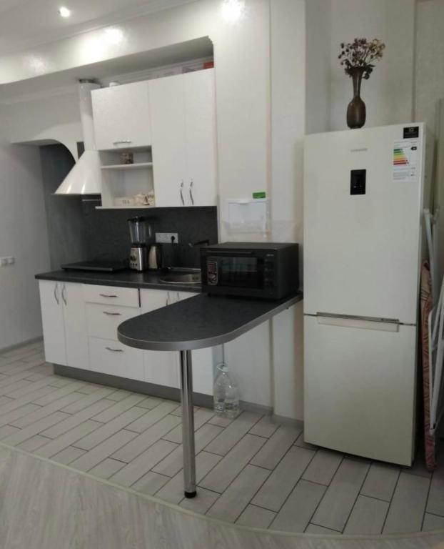 uma cozinha com uma mesa e um frigorífico em VIP apart 416 em Tbilisi