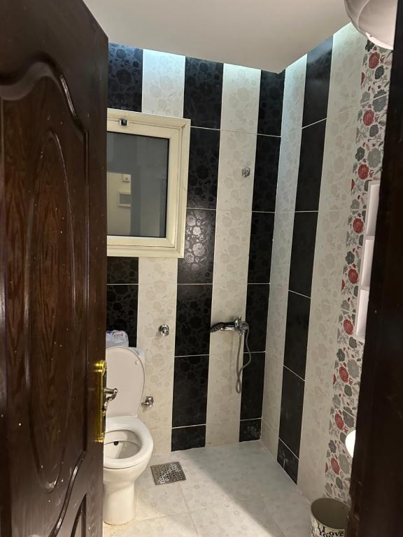 a bathroom with a toilet and a mirror at كمبوند اللوتس in Hurghada