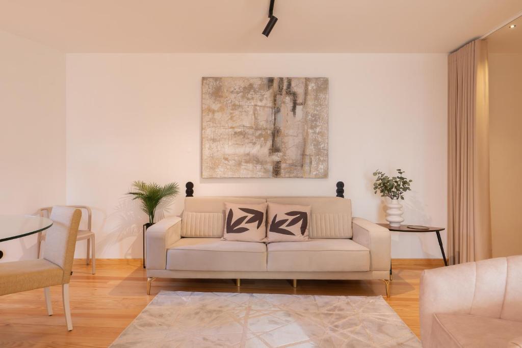 a living room with a white couch and a painting at Luxurious Bright Flats - Ace Location in Porto