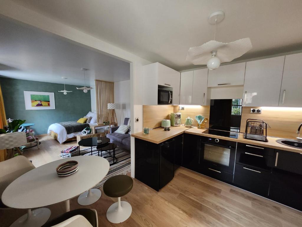 a kitchen and living room with a table and a living room at Le domaine de Bachmay in Laval