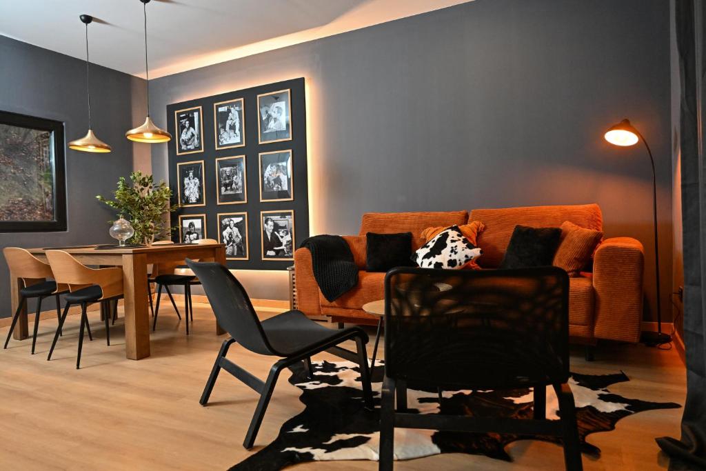 Una sala de estar con un sofá y una mesa con sillas. en La Tulipe Noire, en Bran