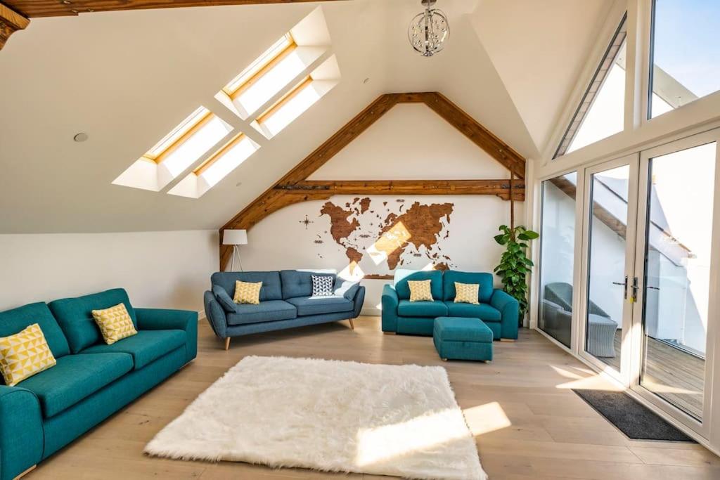 una sala de estar con sofás azules y un mapa en la pared en Neptune, en Saundersfoot
