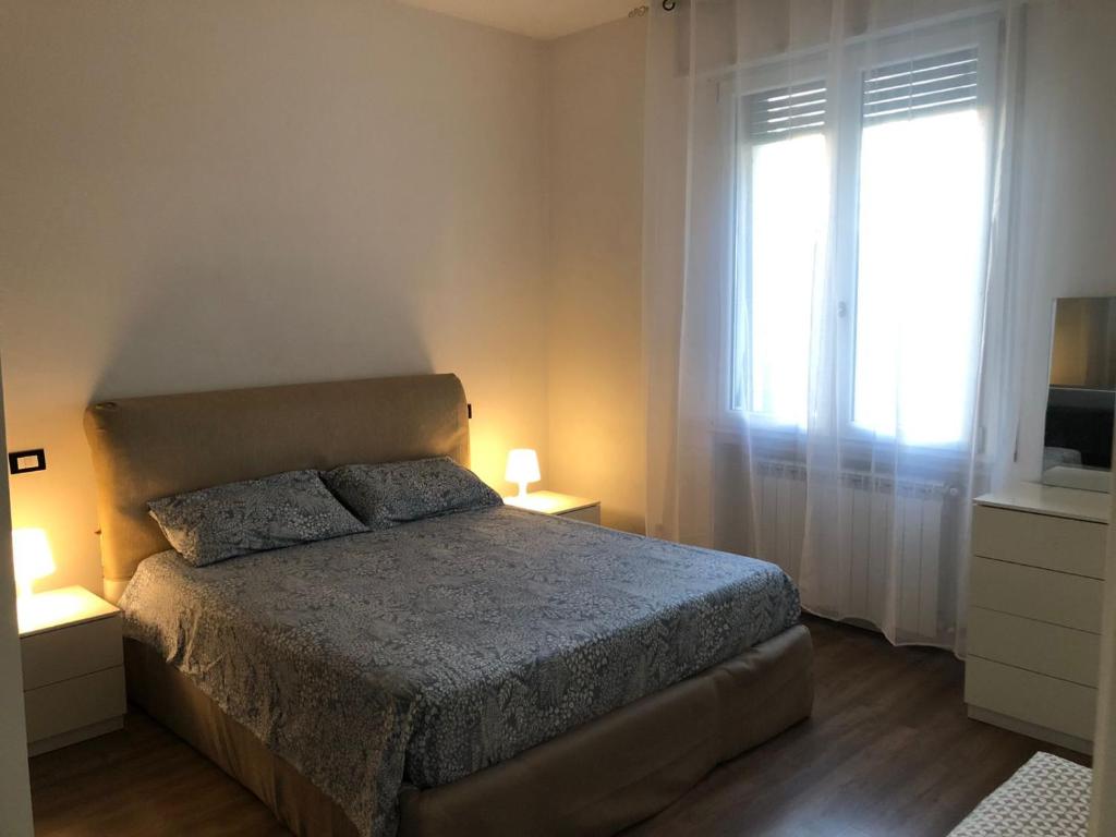 1 dormitorio con cama y ventana grande en Cozy House, en Arezzo