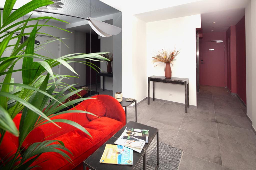 a living room with a red couch and a plant at FINESTATE Coliving Champs-Elysées in Paris