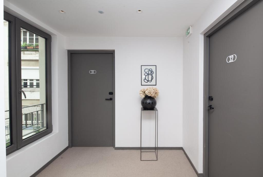 a hallway with two doors and a vase on a shelf at FINESTATE Coliving Champs-Elysées in Paris