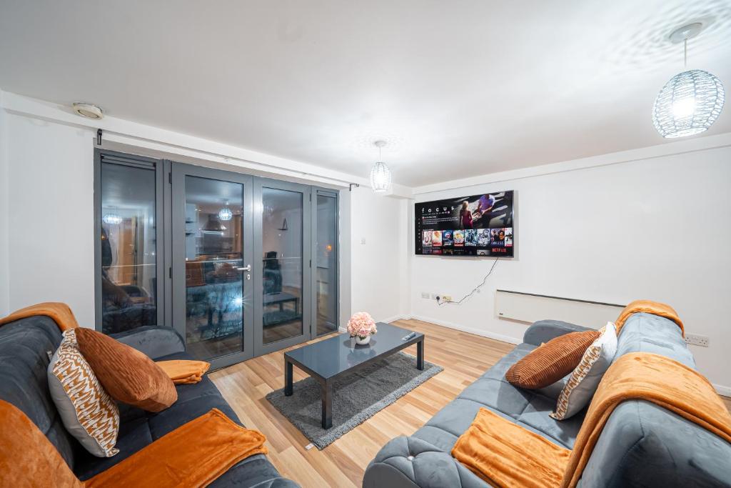 ein Wohnzimmer mit einem Sofa und einem TV in der Unterkunft Spacious 2 Bedroom 6 Minute Drive from Huddersfield Town Centre - Ideal Stay in Huddersfield