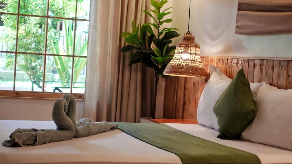 a stuffed animal on a bed in a bedroom at Senare Boracay Hotel in Boracay