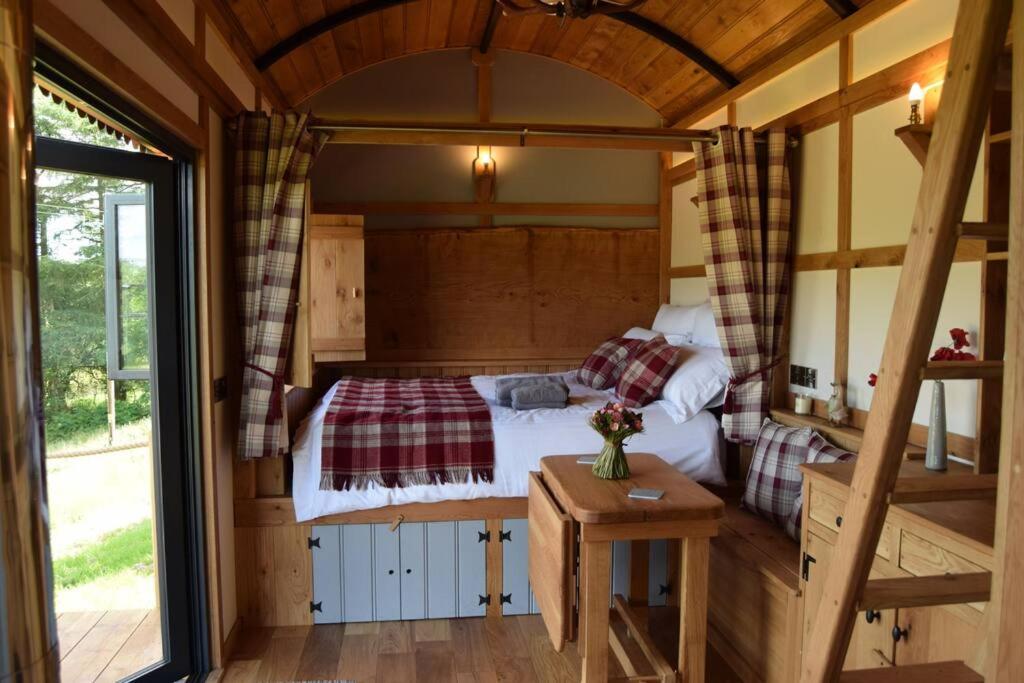 a bedroom with a bed in a wooden house at The Flying Scotsman Shepherd's Hut with Hot Tub in Brecon