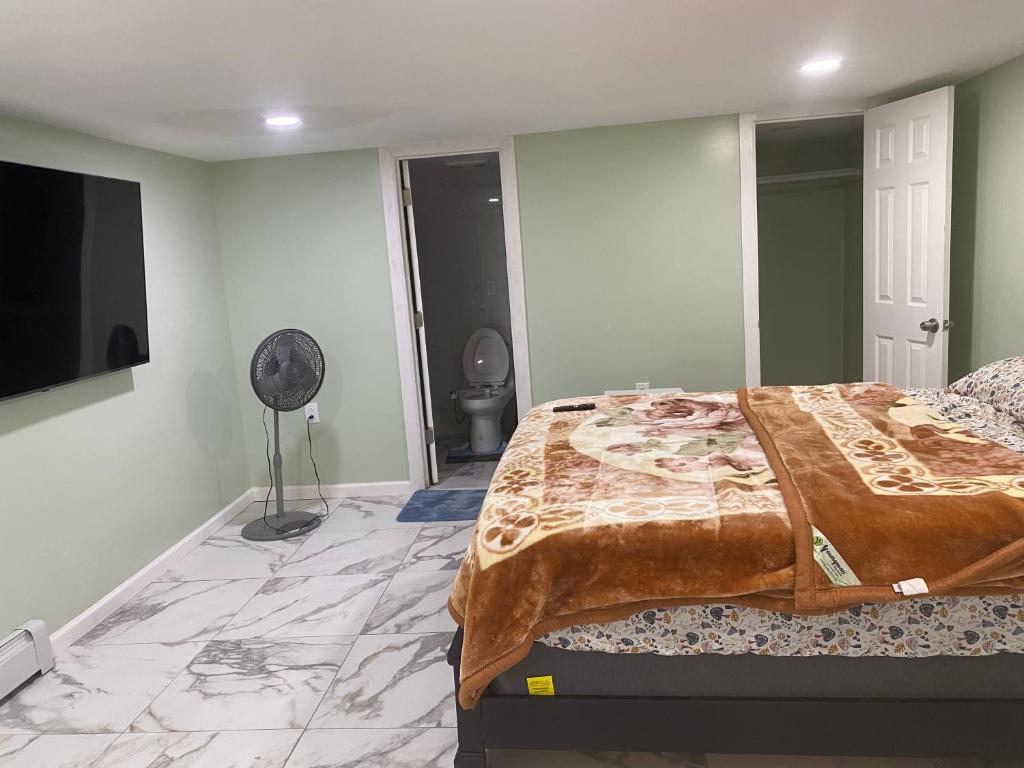 a bedroom with a bed and a flat screen tv at Single Room in Elmont