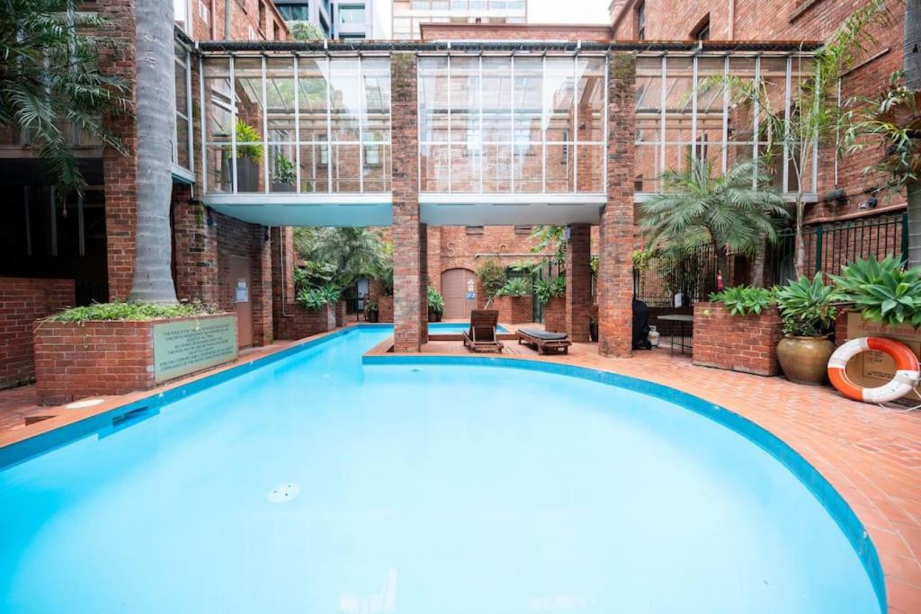 ein großer Pool in einem Innenhof mit einem Gebäude in der Unterkunft Gordons Place Entire Apartment CBD Location in Melbourne