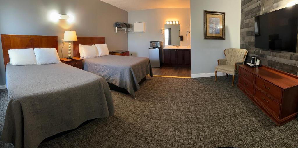 a hotel room with two beds and a flat screen tv at Pelican Motel in Pelican Rapids