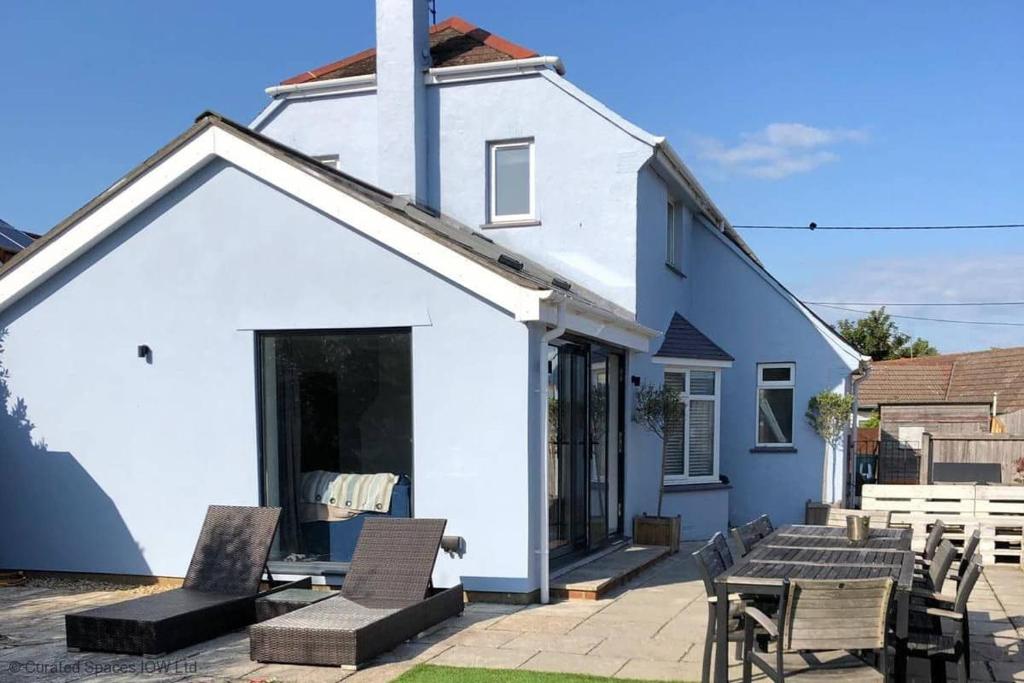 a white house with chairs and a table at San Rocco in Bembridge