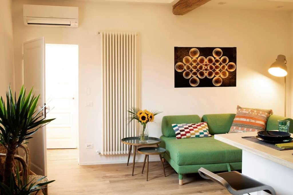 Una sala de estar con un sofá verde y una mesa. en Cozy apartment in Pratello, en Bolonia