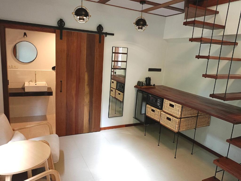 ein Wohnzimmer mit einer Treppe und einem Tisch in der Unterkunft The Reef Hotel & Studios in Ko Lipe