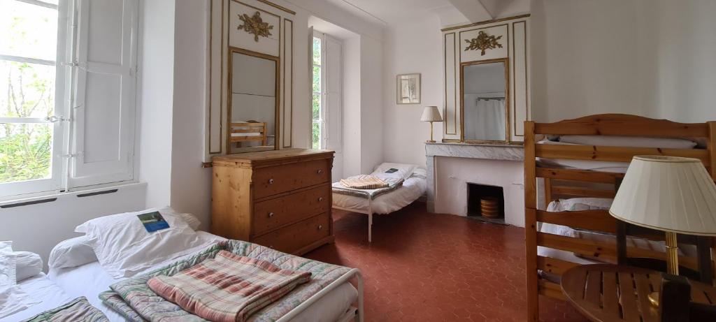 a bedroom with a bed and a fireplace and a dresser at Gîte Marronnier in Tourrettes-sur-Loup
