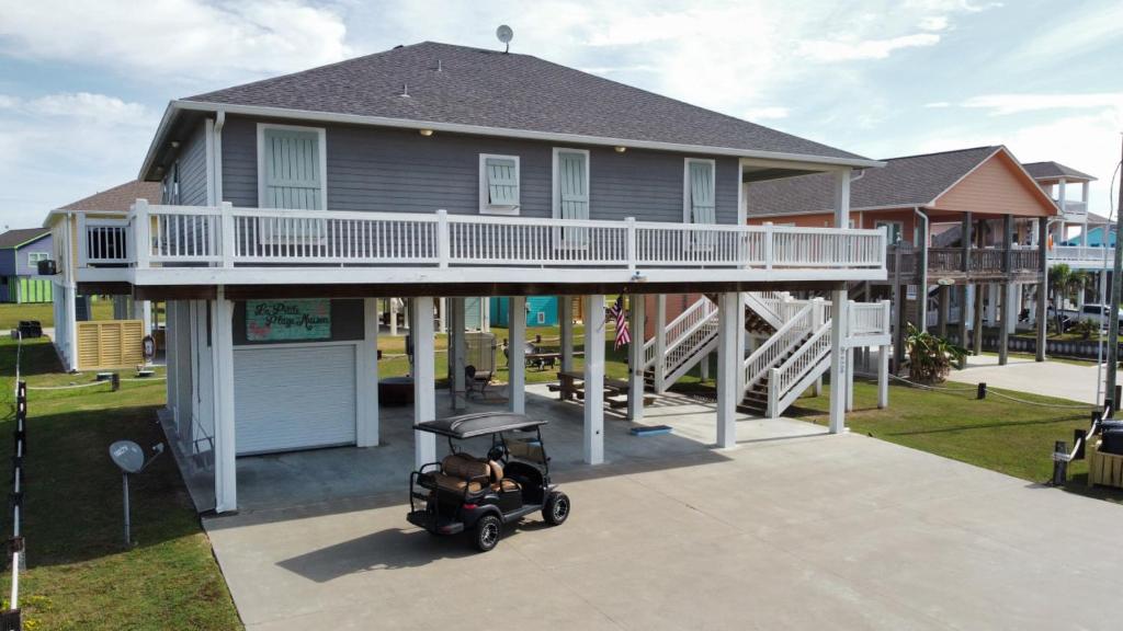 a house with a golf cart in front of it at Hot Tub Golf Cart Near beach Coastal Retreat in Bolivar Peninsula