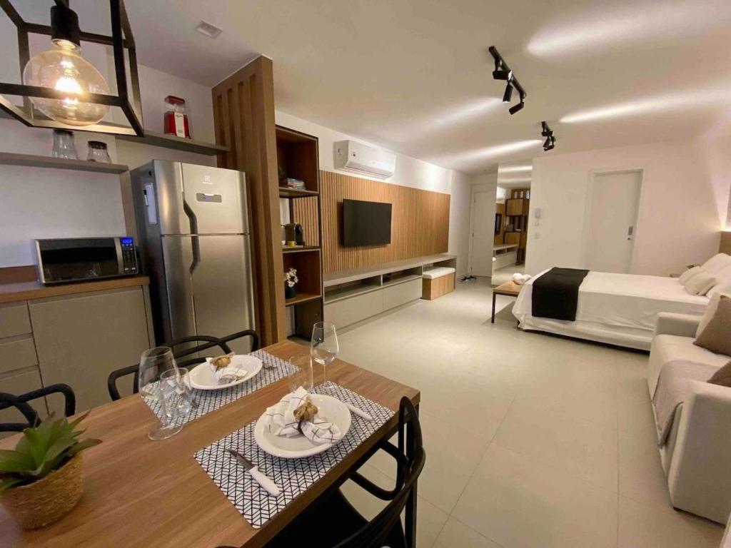 una sala de estar con mesa de comedor y una habitación con cama en Red Design by Mosaico Stays en Vitória