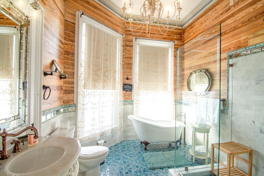 a bathroom with a tub and a toilet and a sink at The Artist House in Key West