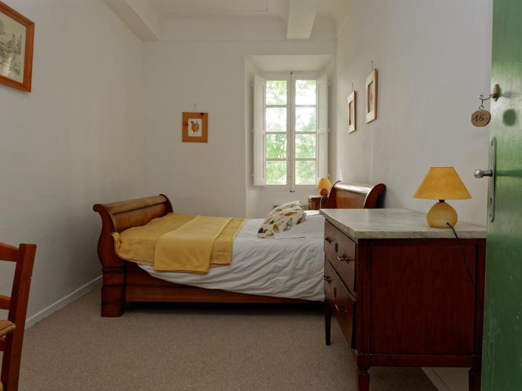 a bedroom with a bed and a dresser and a window at Gîte Marronnier in Tourrettes-sur-Loup