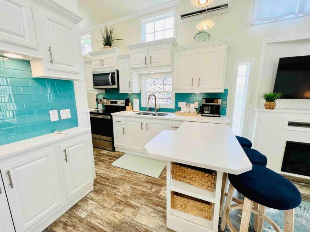 una cocina con armarios blancos y detalles azules en Vacation Cottage North Myrtle Beach 65, en Myrtle Beach