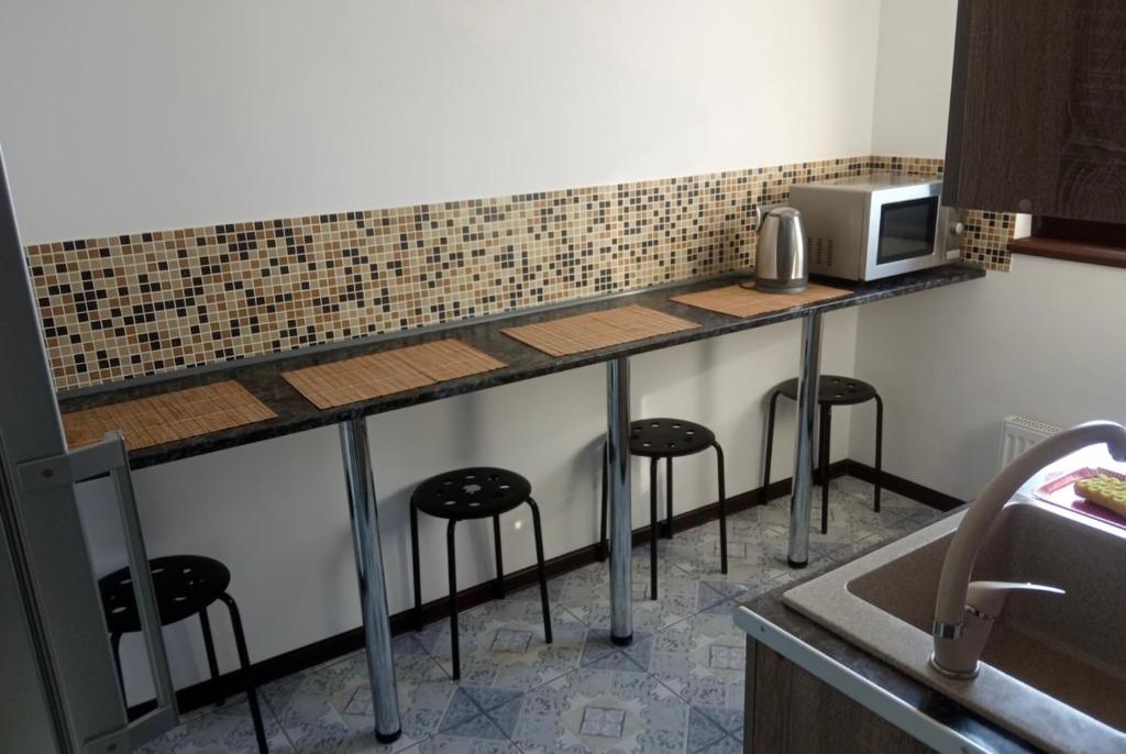 uma cozinha com um balcão com bancos e um micro-ondas em VIP apart 421 em Tbilisi