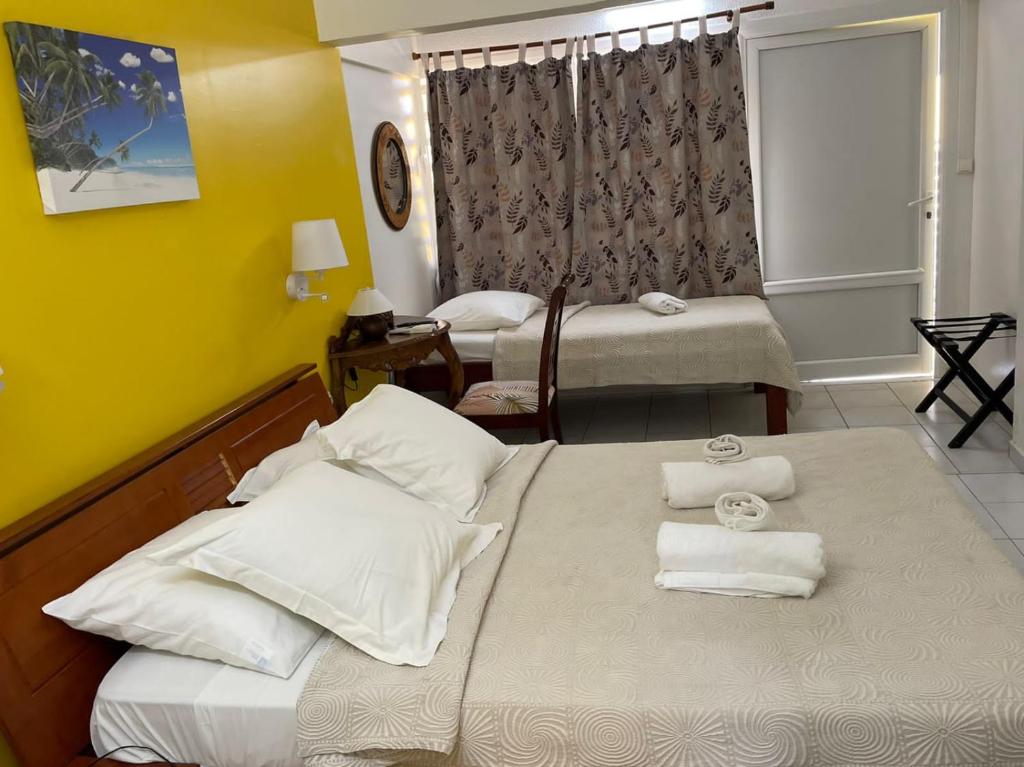 a hotel room with two beds with towels on them at Hotel Le Rotabas in Sainte-Anne