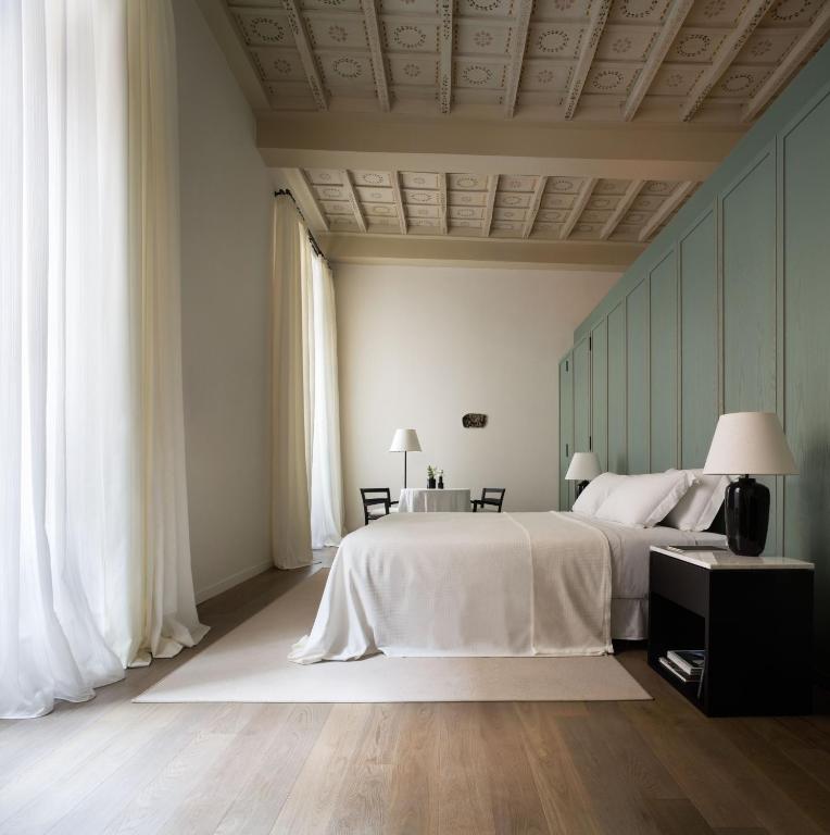 Hotel Parisii Bocca di Leone 88, a bedroom with a large white bed and two windows at Parisii Bocca di Leone 88 in Rome