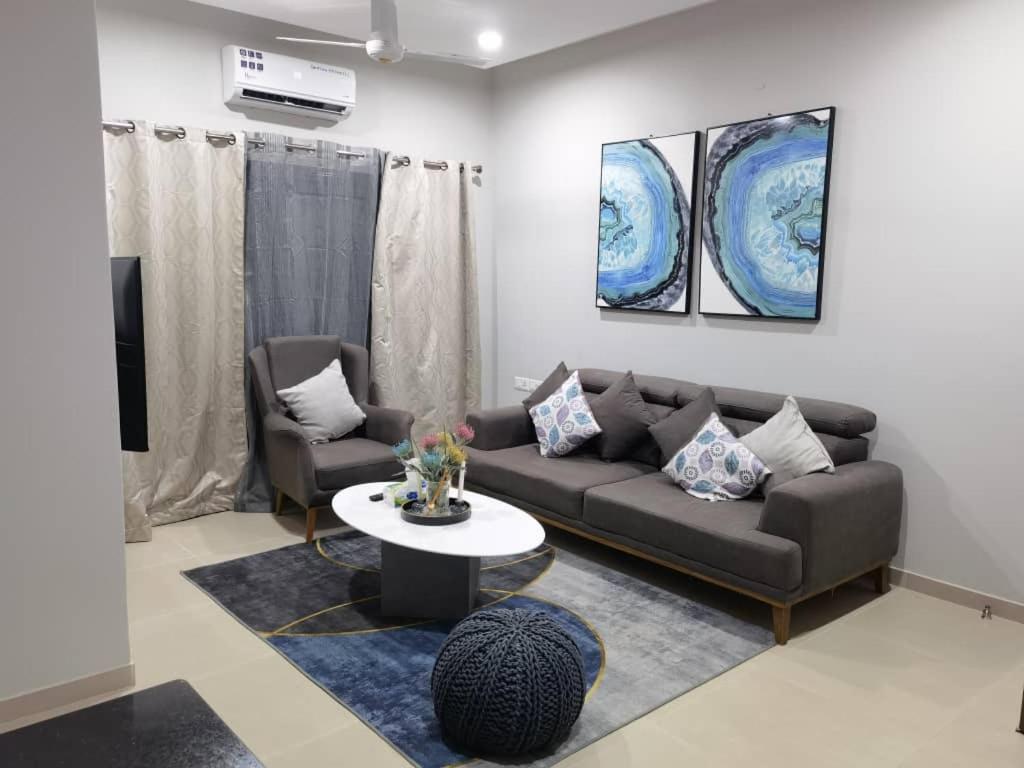 班珠尔Modern 2-bedroom unit with pool and beach access的带沙发和桌子的客厅