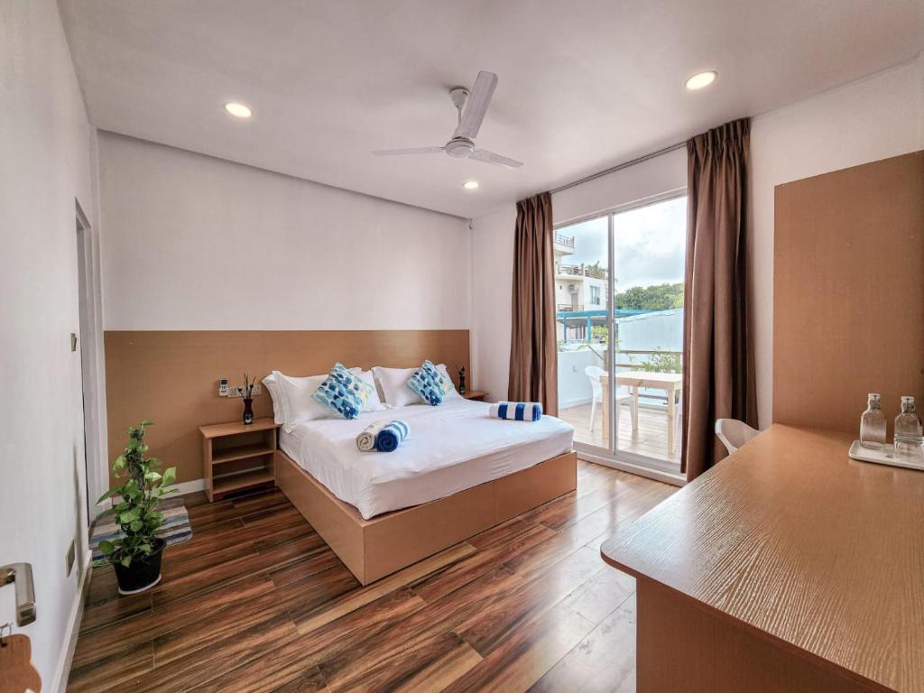 um quarto com uma cama com almofadas azuis em Raalhu Fonu Maldives em Mahibadhoo