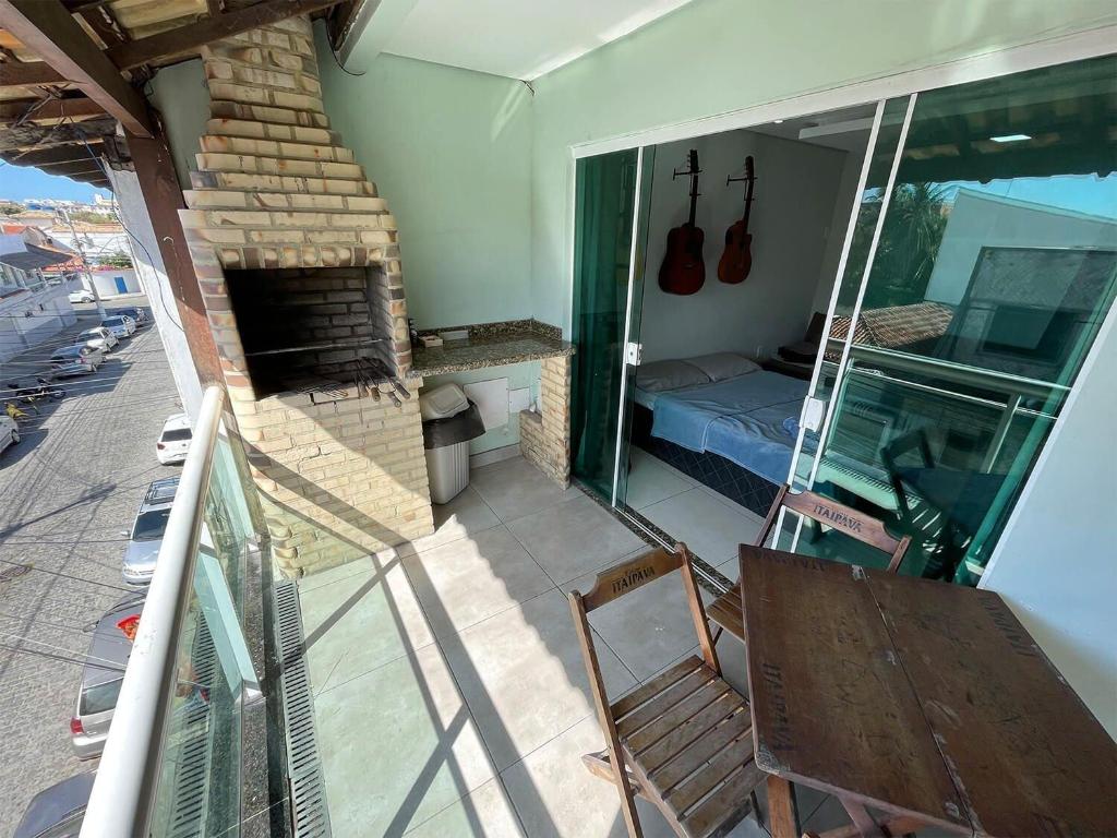Il dispose d'un balcon et d'une chambre avec un lit et une cheminée. dans l'établissement The Férias | Suites Luxo, à Cabo Frio
