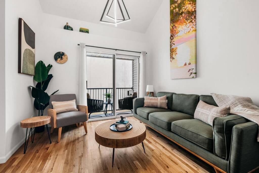 un soggiorno con un divano verde e un tavolo di Japandi, 3BD Townhome Near Downtown, Beach and Wineries a Traverse City