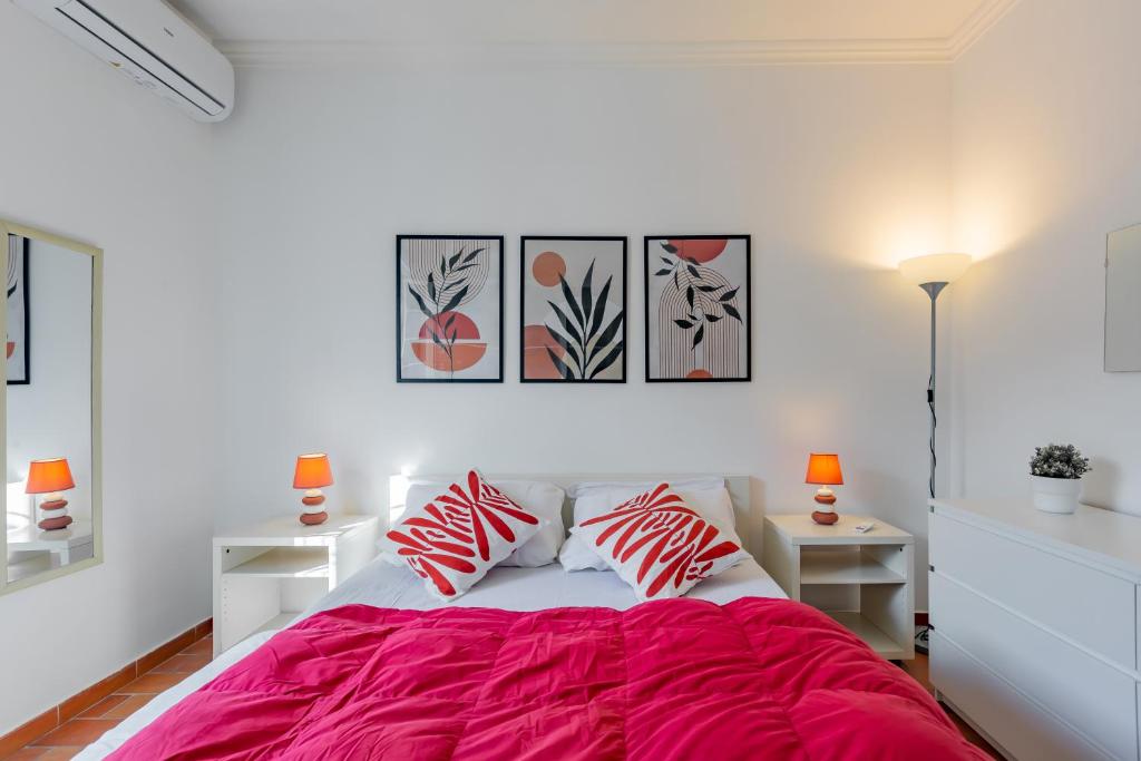 a white bedroom with a bed with red sheets at Milvio Bridge - cozy apartment in Rome in Rome