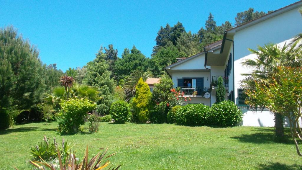 una casa con un patio con arbustos y árboles en Casa Pinho, en São Pedro do Sul