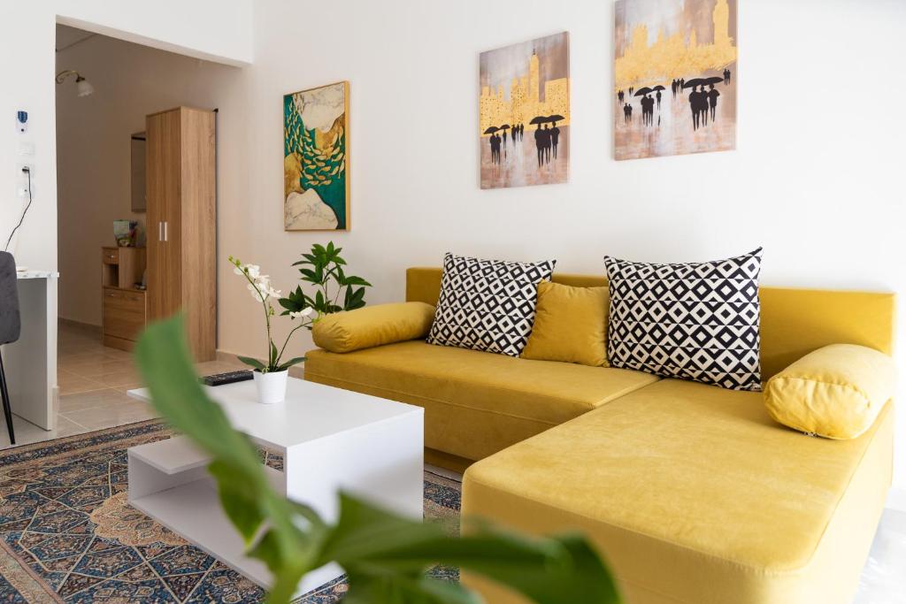sala de estar con sofá amarillo y mesa en Cozy Central Apartment, en Larisa